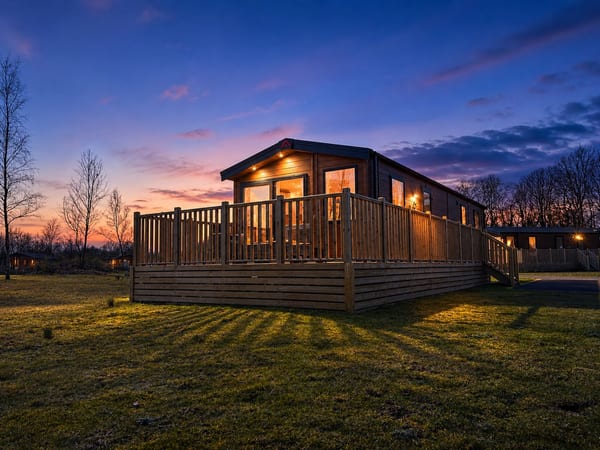 The Sahara — lodge with lit decking at dusk, South Lakeland Leisure Village